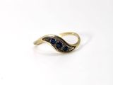 a close up of a gold ring with a blue stone