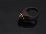 a close up of a wooden ring on a black surface