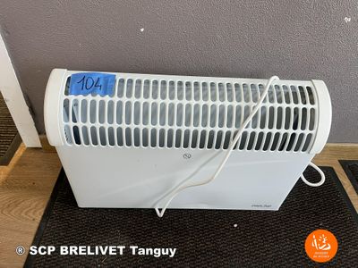 a white heater sitting on the floor in front of a gray wall