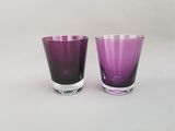une paire de verres à eau en verre violet sur fond blanc