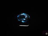 a close up of a blue diamond on a black surface