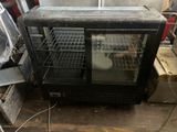 a glass display case with a cat inside of it