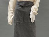 a mannequin wearing a skirt and blouse with a frillying collar