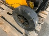 a yellow tractor with a black tire on a pallet