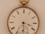 a gold pocket watch with roman numerals on the face
