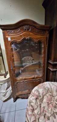un meuble en bois avec une porte en verre dans une pièce