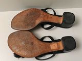 pair of black leather sandals with black straps on a white surface
