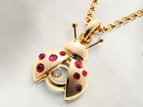 Collier avec une coccinelle en or et des rubis, monté sur une chaîne plaquée or