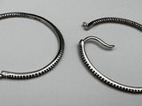pair of silver hoop earrings on a white surface