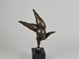 sculpture en bronze représentant un oiseau, posée sur un socle en marbre noir