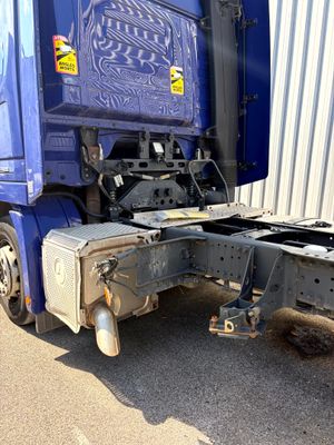 un semi-remorque bleu garé devant un immeuble