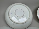 three plates and a bowl sitting on a table