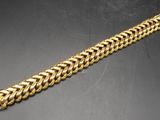 an image of a gold bracelet on a black surface