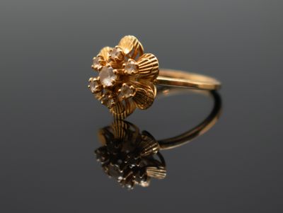 Gros plan sur une bague en or ornée d'une fleur