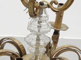 a chandelier that has a glass candle holder on it
