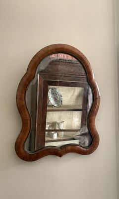 un miroir accroché au mur à côté d'une fenêtre