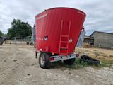 a red tractor trailer with a red grainer on the back