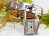 a silver watch with a padlock on a brown leather strap