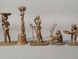 four bronze figurines of a man, woman, child, and dog