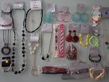 a lot of necklaces and bracelets hanging on the wall