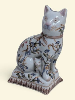une figurine de chat bleue et blanche posée sur un socle