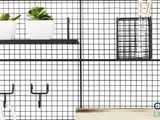 une étagère en fil de fer noir sur laquelle sont posés des pots et des plantes
