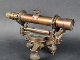 an old brass telescope on a stand on a gray background