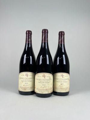 trois bouteilles de vin rouge sont posées les unes à côté des autres sur une table
