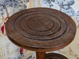 a wooden table with two stools in front of a wallpapered wall