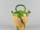 a green and yellow vase with a handle on it