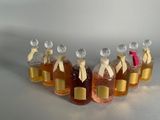 six bottles of honey sit in a row on a white surface