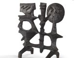 pair of black iron candlesticks with faces on them on a white background