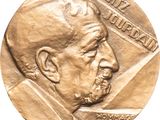 an image of a gold medal with a man ' s face on it