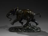 bronze statue of an elephant on a rock with a shadow on a gray background