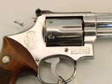 a revolver with a wooden handle on a white table