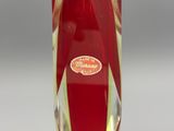 a red glass vase with a gold base and a white base
