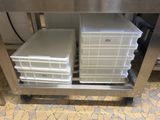 two plastic containers are stacked on top of a stainless steel table