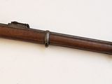 un fusil en bois accroché au mur, avec une arme posée dessus