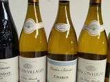 six bottles of wine are lined up in a row on a table