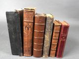 plusieurs vieux livres sont alignés sur une surface grise