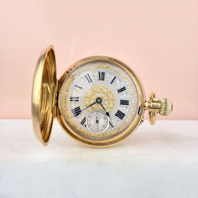 une image d'une montre de poche en or avec des chiffres romains sur le cadran