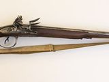 un pistolet et un fusil accrochés l'un à côté de l'autre sur un mur