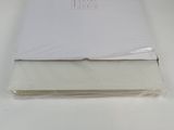 a white book on a white table with a small bird on top of it