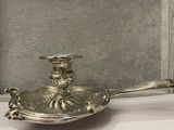 a silver plate with a candle on it on a table