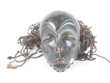 a black mask with dreads on it on a white surface