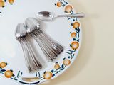 a plate with spoons and silverware on it