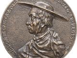 une image représentant une médaille de bronze sur laquelle figure un homme coiffé d'un chapeau
