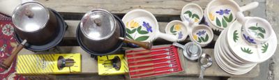 many bowls and pans that are hanging on the wall