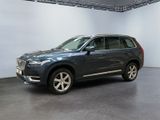 a grey volvo suv parked in a showroom with a white wall