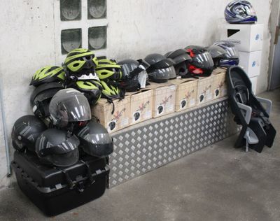 a pile of helmets sitting on a bench in a garage